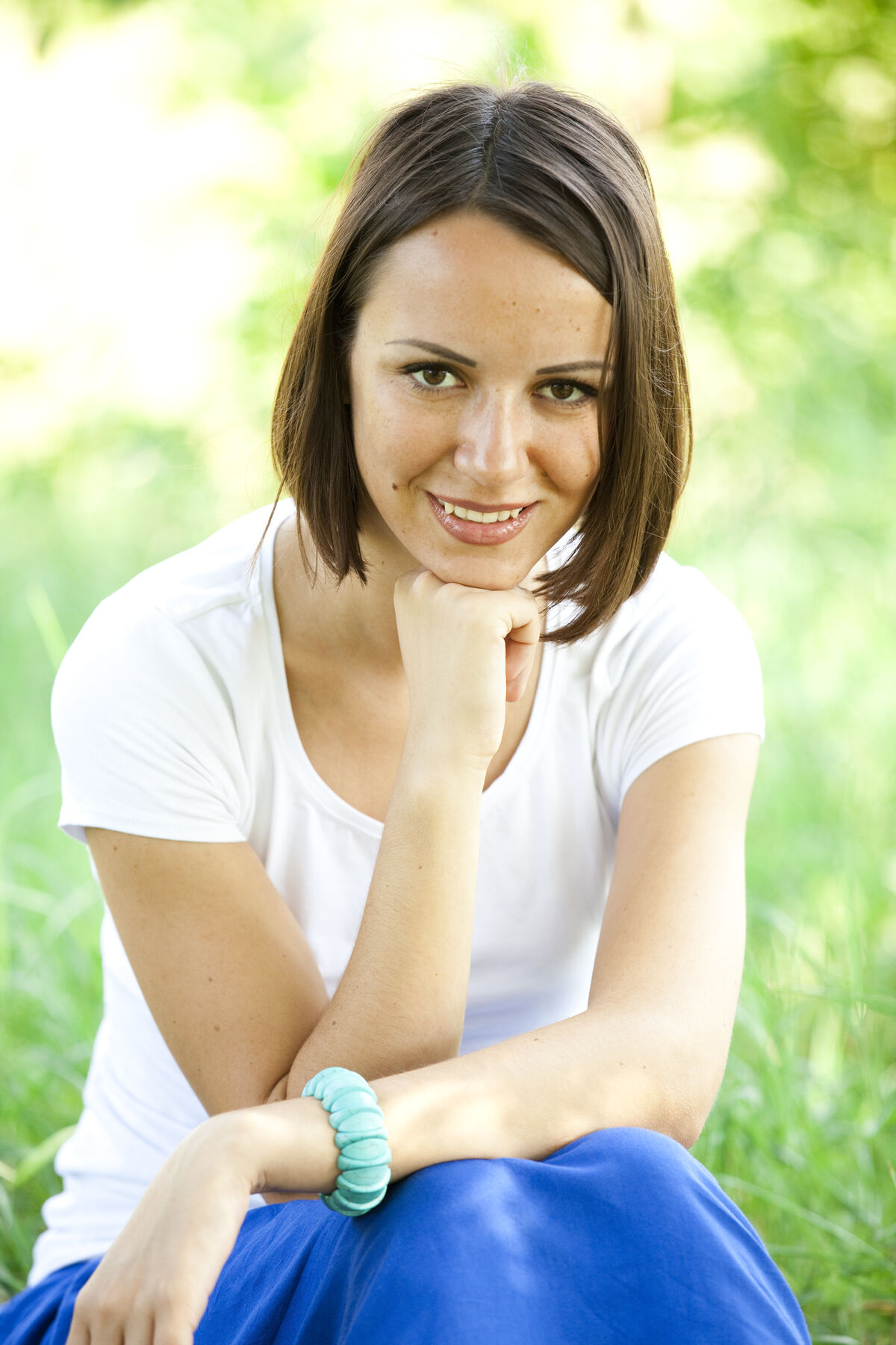 A young woman walking through a sunlit park, calm and focused.